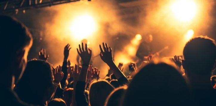 silhouettesofhandsonconcertinfrontofbrightstage