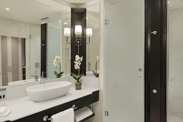 Elegant marble bathroom with sleek vanity, large mirror, and modern glass shower at Fairmont Windsor Park.