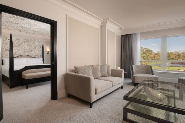 Premium One Bedroom Suite at Fairmont Windsor Park with separate living area, plush seating, and scenic garden views.
