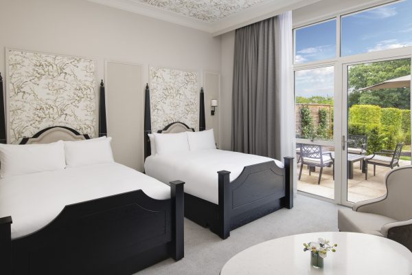 Elegant room with two queen beds, floral headboards, and private patio at Fairmont Windsor Park.