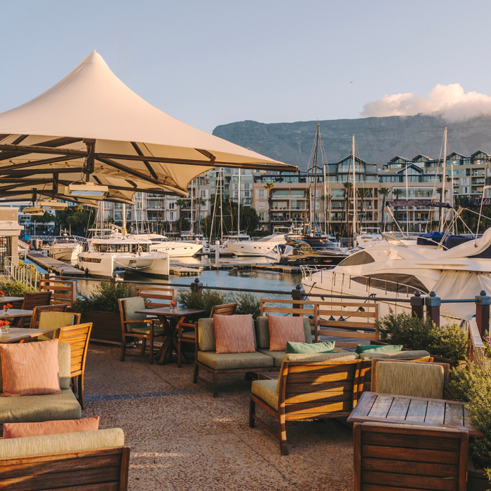 Bascule-Bar-GA2-Square The outdoor marina terrace at Bascule Bar, Cape Grace, with seating overlooking the V&A Waterfront and Table Mountain in the background.