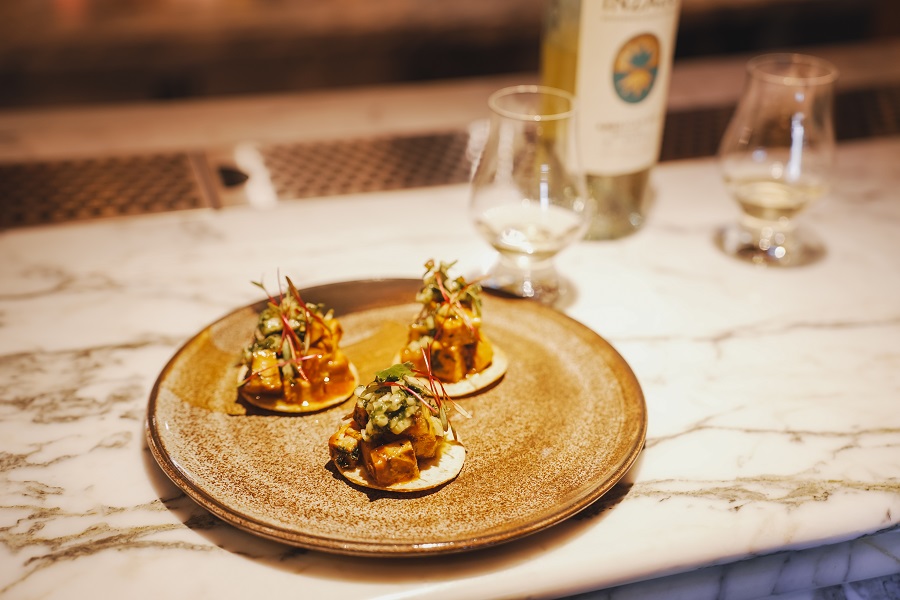 DSC02878 Pork Belly Tostadas with pineapple chimichurri – three crisp tostada bases topped with glazed pork belly, fresh salsa, and red micro herbs.
