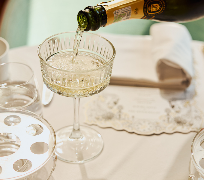 Cap Classique being poured into an elegant crystal coupe glass at Cape Grace hotel, Heirloom Restaurant, V&A Waterfront, Cape Town.