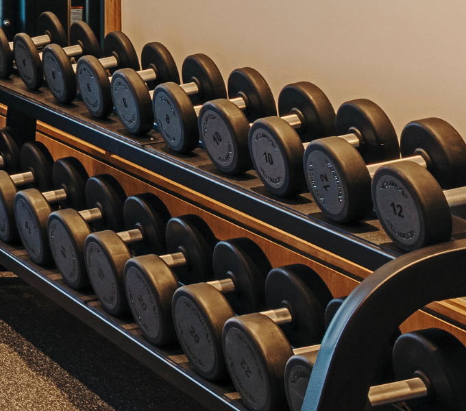 Neatly arranged set of dumbbells on a rack in the Fairmont Fit gym at Cape Grace, showcasing a well-equipped and modern fitness space.