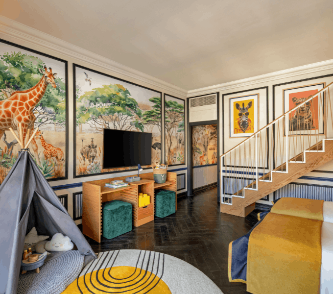 Spacious children’s living area at Cape Grace with safari-inspired wall art, play tent, and entertainment space designed for families.