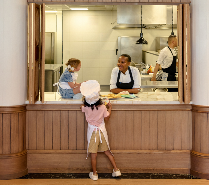 Children enjoying a hands-on biscuit decorating experience with chefs in the Cape Grace kitchen, highlighting a fun and interactive family activity.