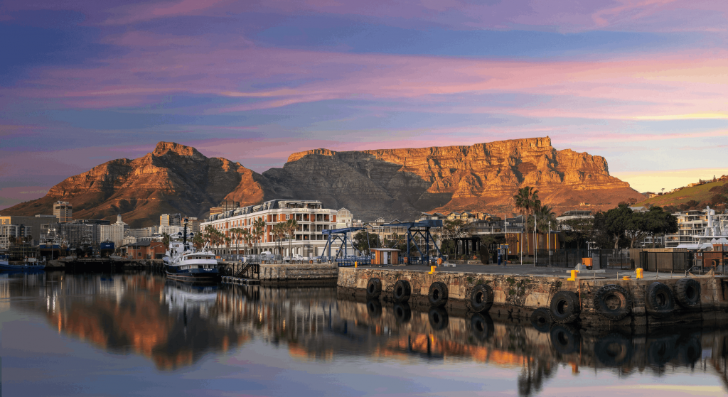Cape Grace hotel on Cape Town’s V&A Waterfront, with Table Mountain at sunset reflected in the marina.