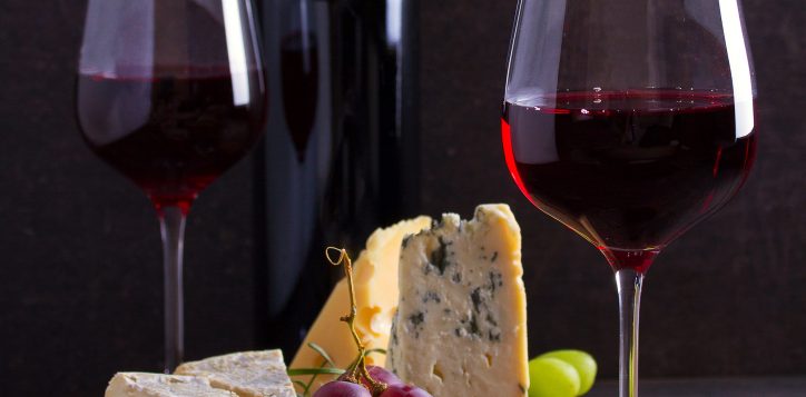 glassandbottleofwinewithcheesegrapesandnuts